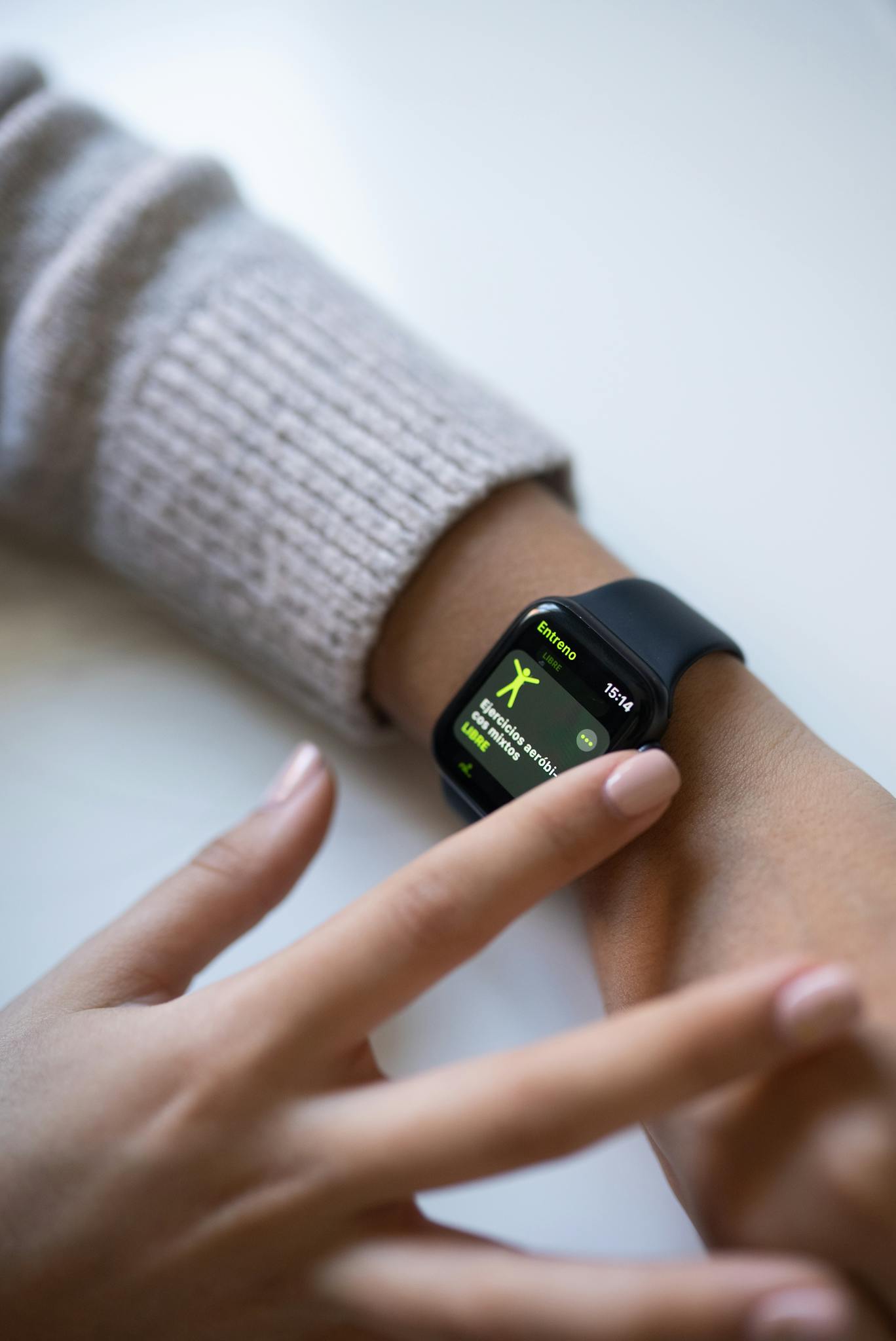 Close-up of a smartwatch interface on a wrist being touched for fitness tracking.